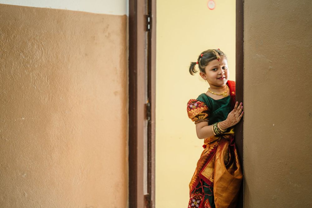 Traditional dance performance in front of a beige wall with warm lighting.