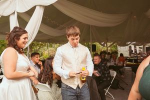 A festive dance party under an elegant white tent with string lights and fabric draping.
