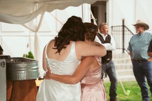 Couples dancing together at an outdoor wedding reception under white tents.