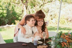A cozy moment shared at a wedding reception table with drinks and decor.