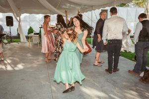 People enjoying music and dancing under a decorated tent during a festive outdoor gathering.