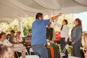 Dancing guests celebrate at a tented wedding reception with draped fabric decor.