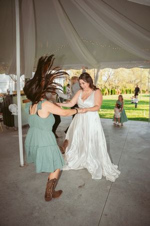 Dynamic dance moves captured under a tent with flowing dresses and cowboy boots.