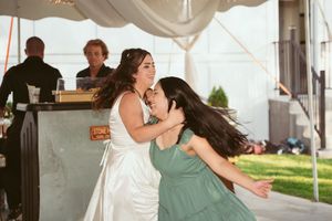 Couples dance in pairs under an elegant white tent during a festive wedding reception.