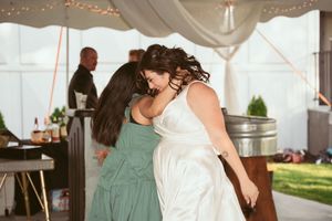 Wedding celebration under a draped tent with guests dancing and mingling on the dance floor.