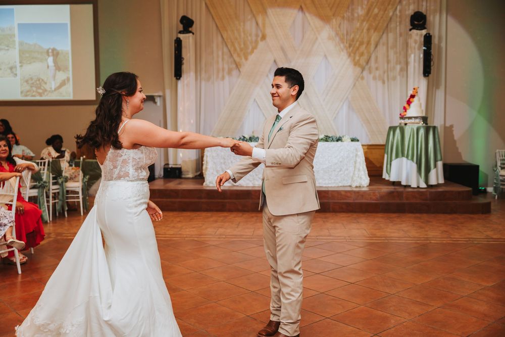 Wedding couple performs their first dance together on a rustic terrace floor during reception celebration.