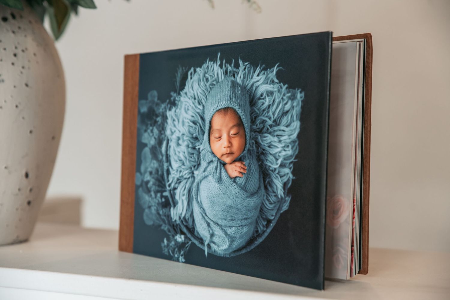 Professional photo album display featuring portraits with blue tonal elements.