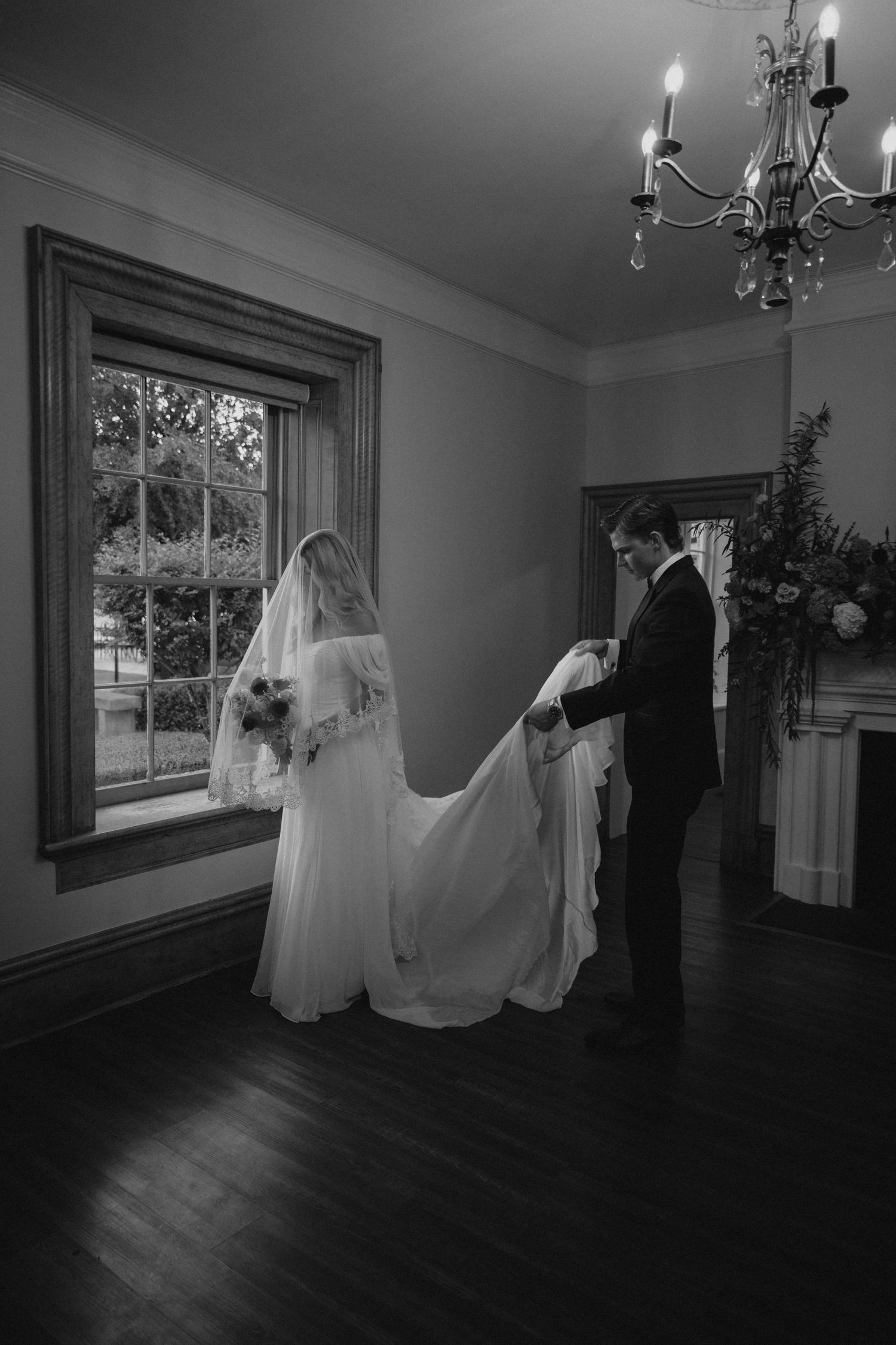 Bride helping groom hold her dress after their wedding at The Bentley House in St. George, Utah