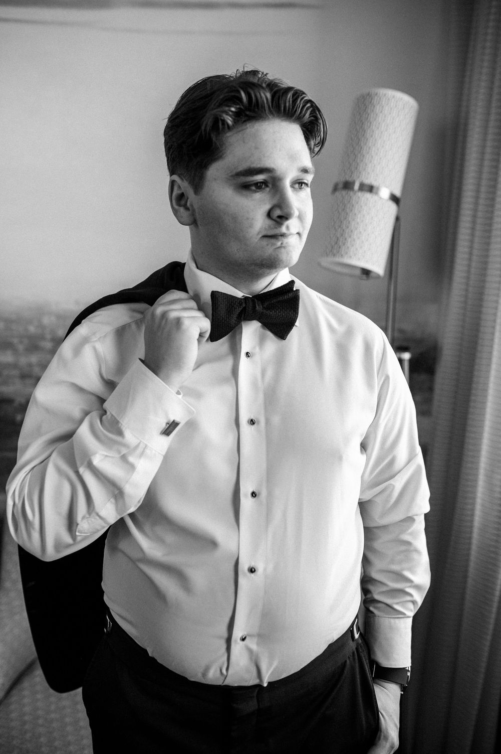 A sequence of black and white portraits showing a person in formal attire adjusting their collar and bow tie.