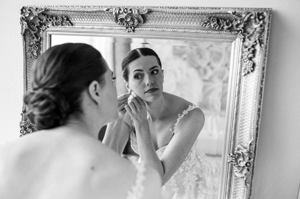 Getting ready scene reflected in an ornate silver mirror.
