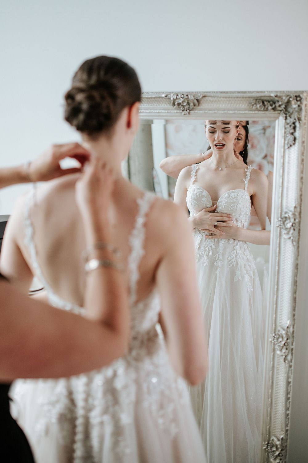 Wedding dress details reflected in an elegant vintage-style mirror.