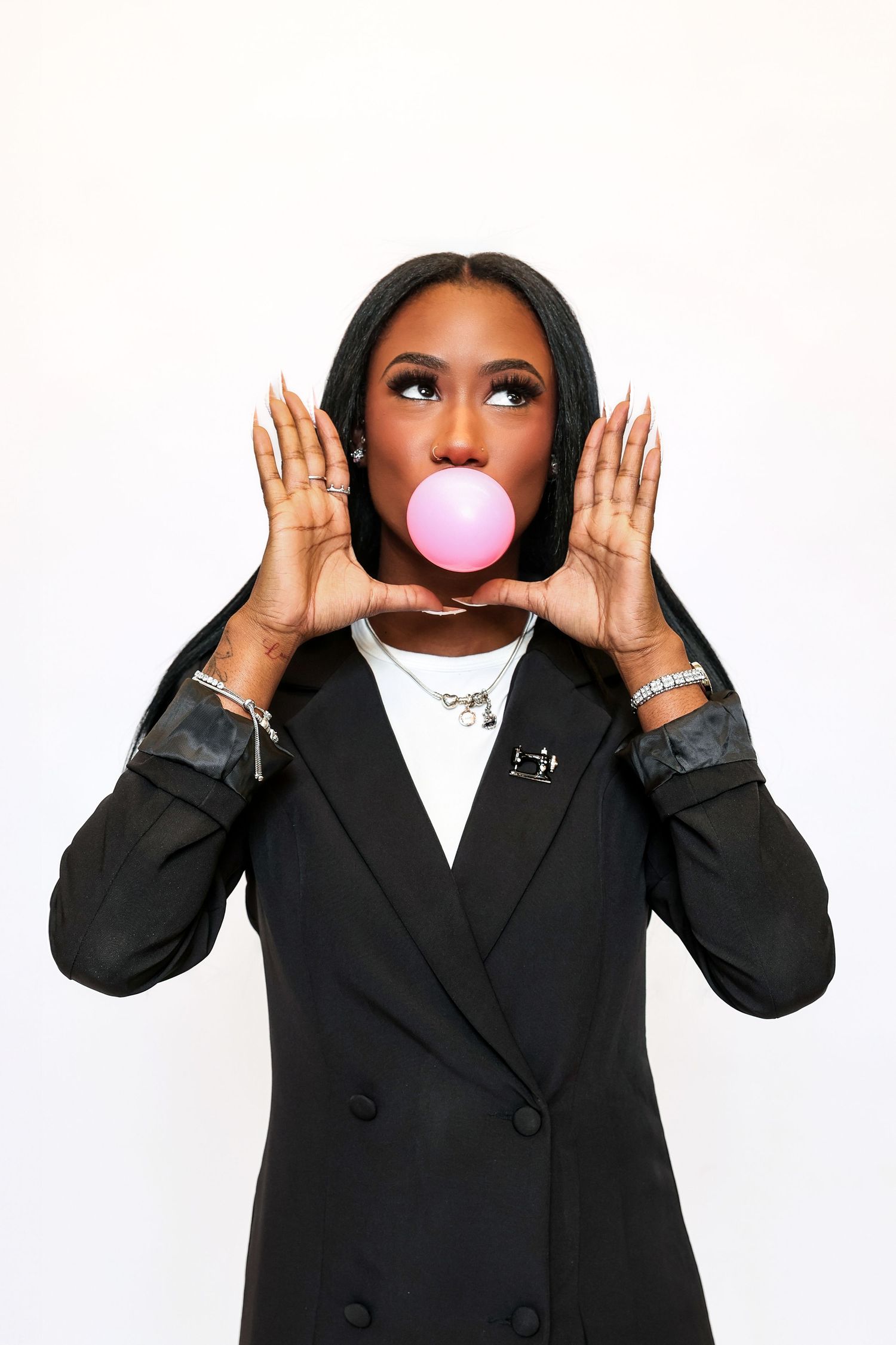 Professional headshots showing playful expressions and pink bubblegum against white background.