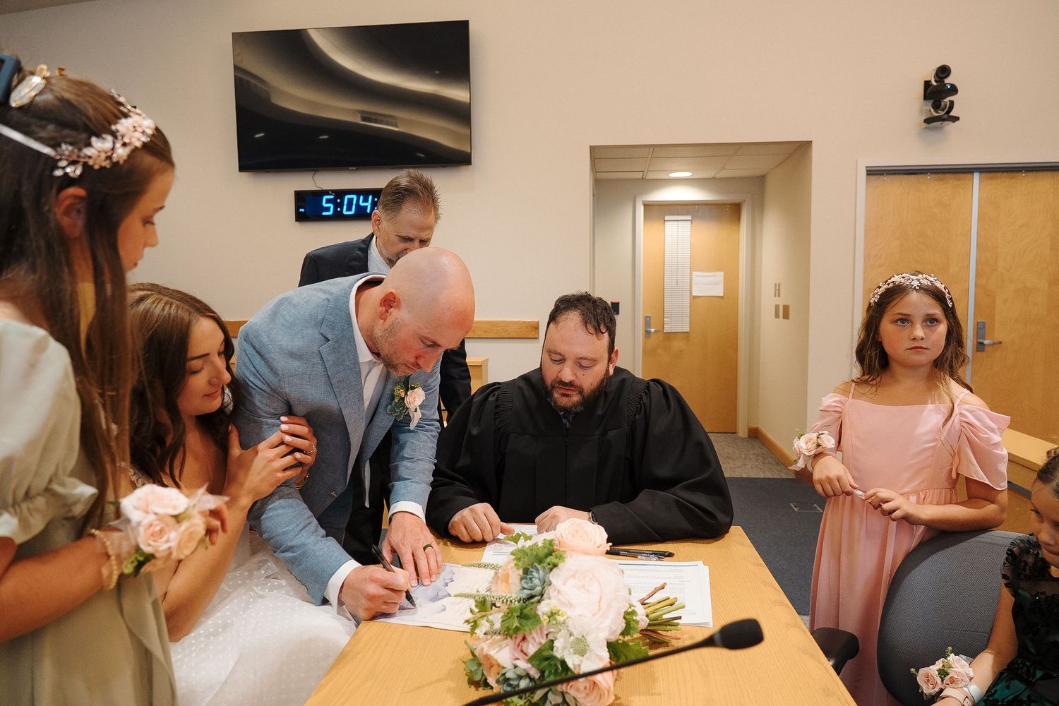 Medical staff gather in a meeting room around a table during a hospital team meeting or training session.