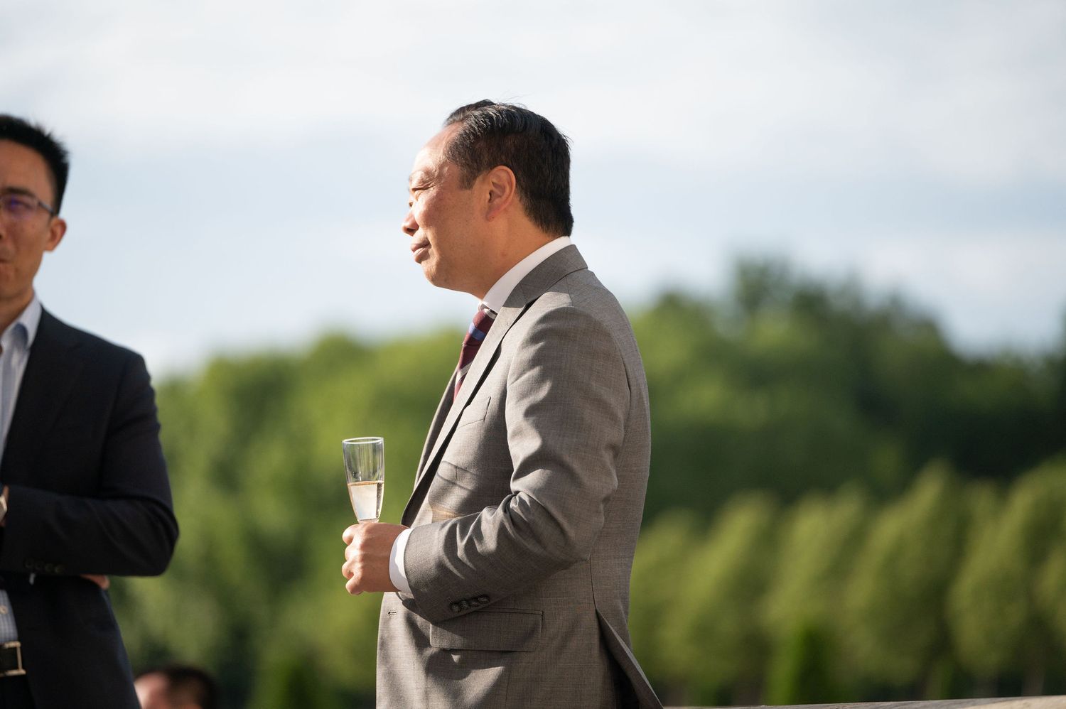Dirigeant en costume, verre de champagne à la main, lors d’un événement corporate dans un château du Centre‑Val  de  Loire