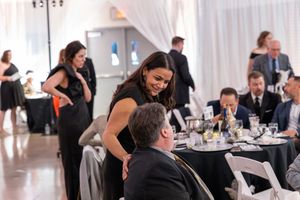 A group enjoying conversation at an elegant black and white formal event in a modern venue.