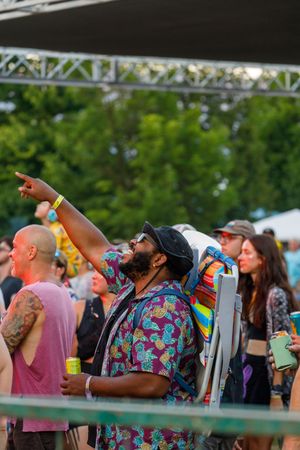 Festival attendees enjoying drinks and music while watching performances from the crowd.