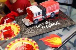Custom red toy trucks with flame designs are displayed on a surface next to each other.