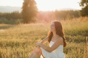 A dreamy sunset photoshoot in a golden meadow with soft backlighting and warm summer evening atmosphere.