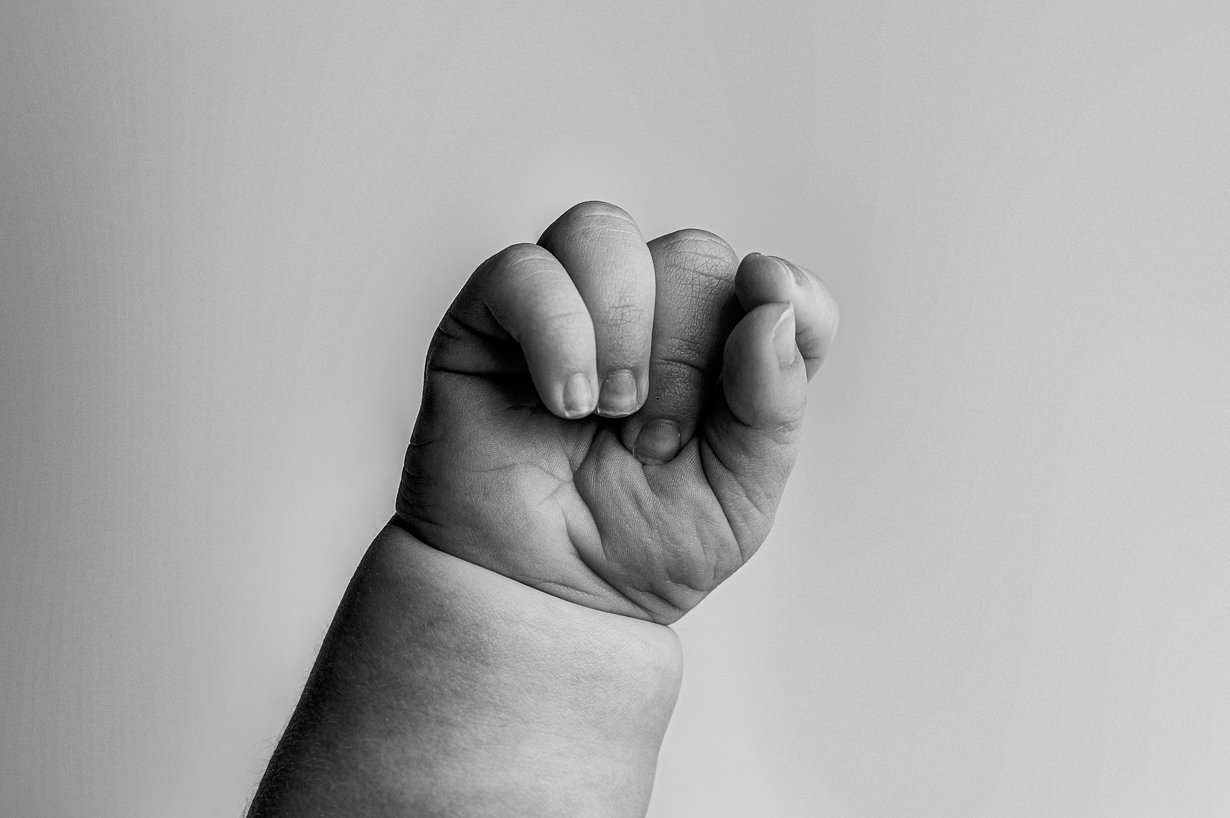 Black and white close-up photographs showing different fist positions and hand gestures in sequence.