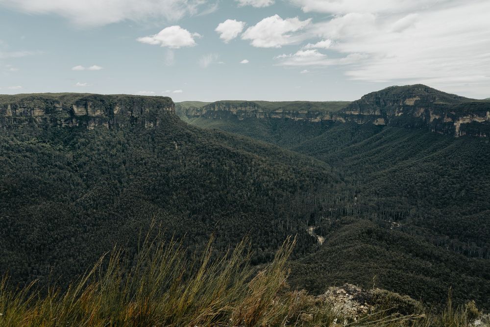 Scenic mountain landscape view of rugged cliffs and forested valleys in the Blue Mountains of Australia.