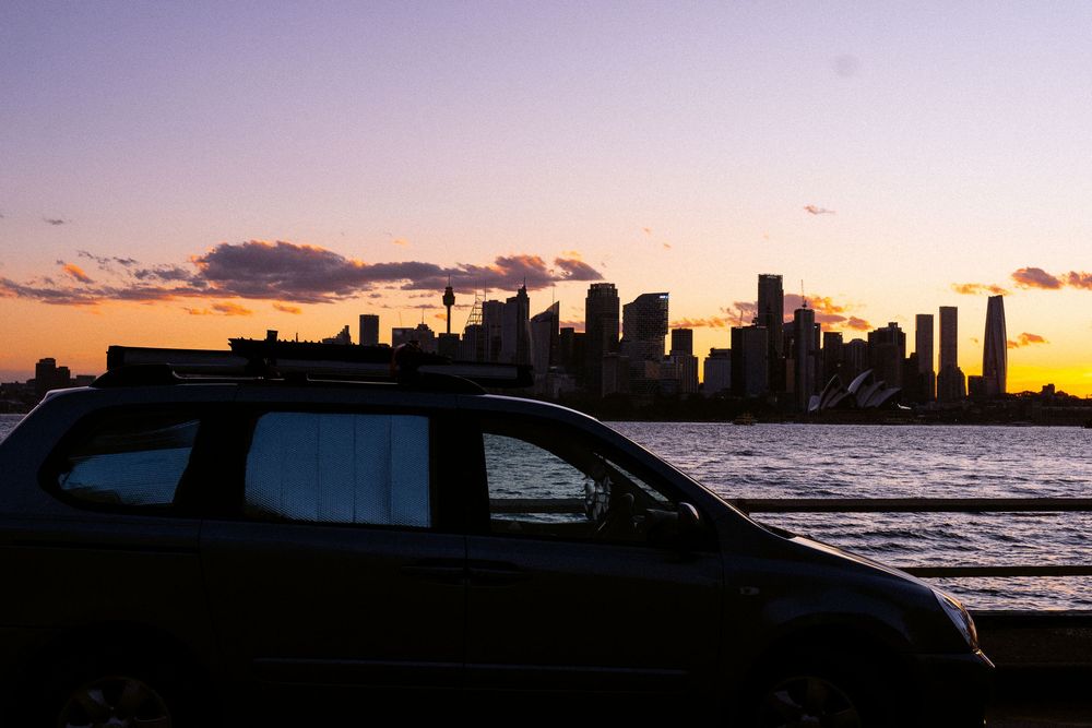 Panoramic sequence of sunset over city skyline with dramatic clouds and silhouetted buildings against orange sky.