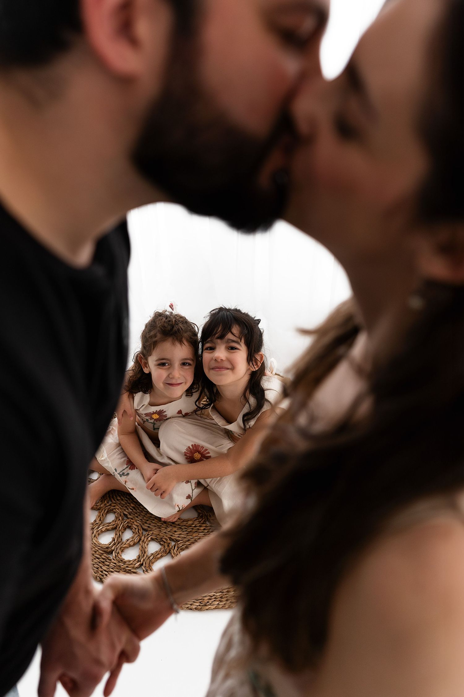 Two young children in formal wear snuggle together and smile warmly during a special occasion.