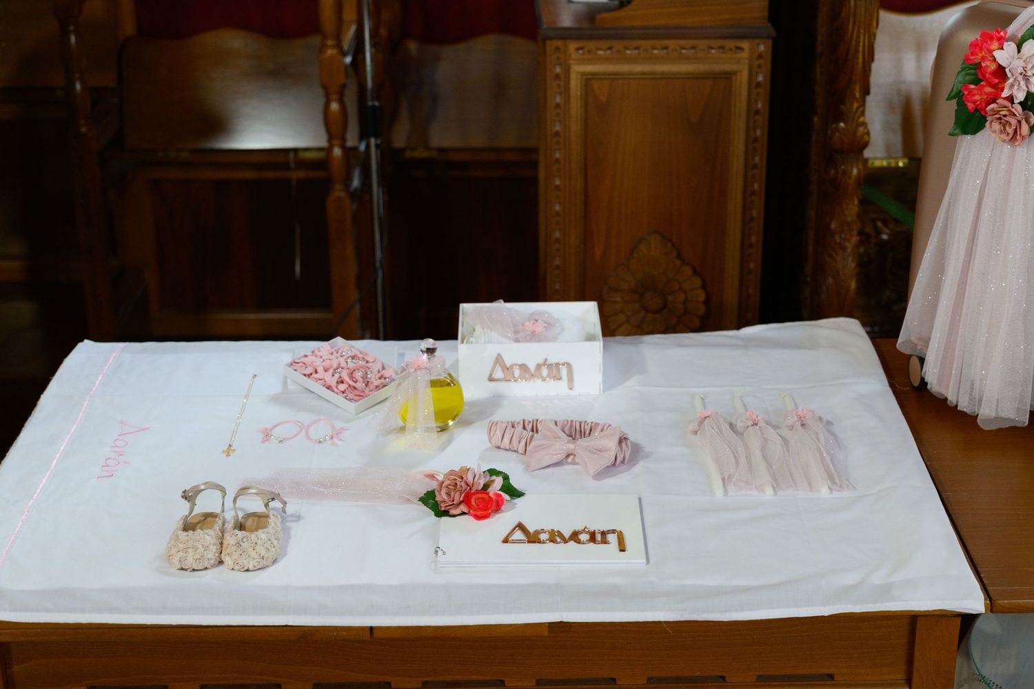 White reception table decorated with place settings and floral arrangements.