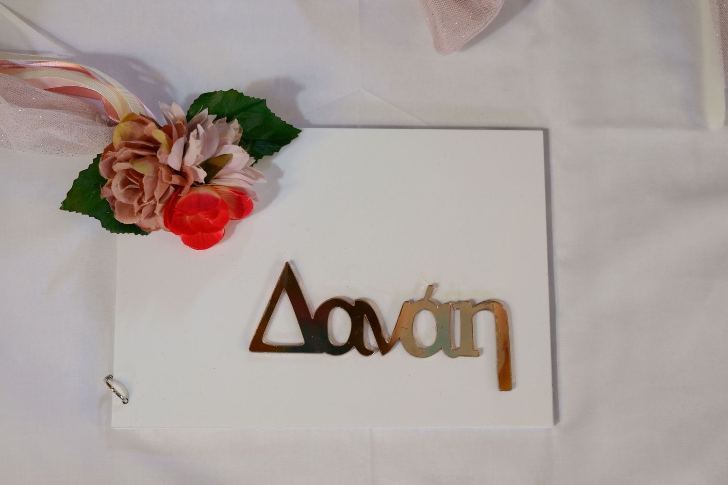 White card with 'Davan' text decorated with pink and coral flowers.