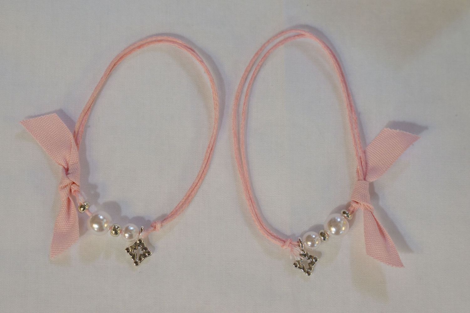 Pink ribbon headbands adorned with bows and crown charms.