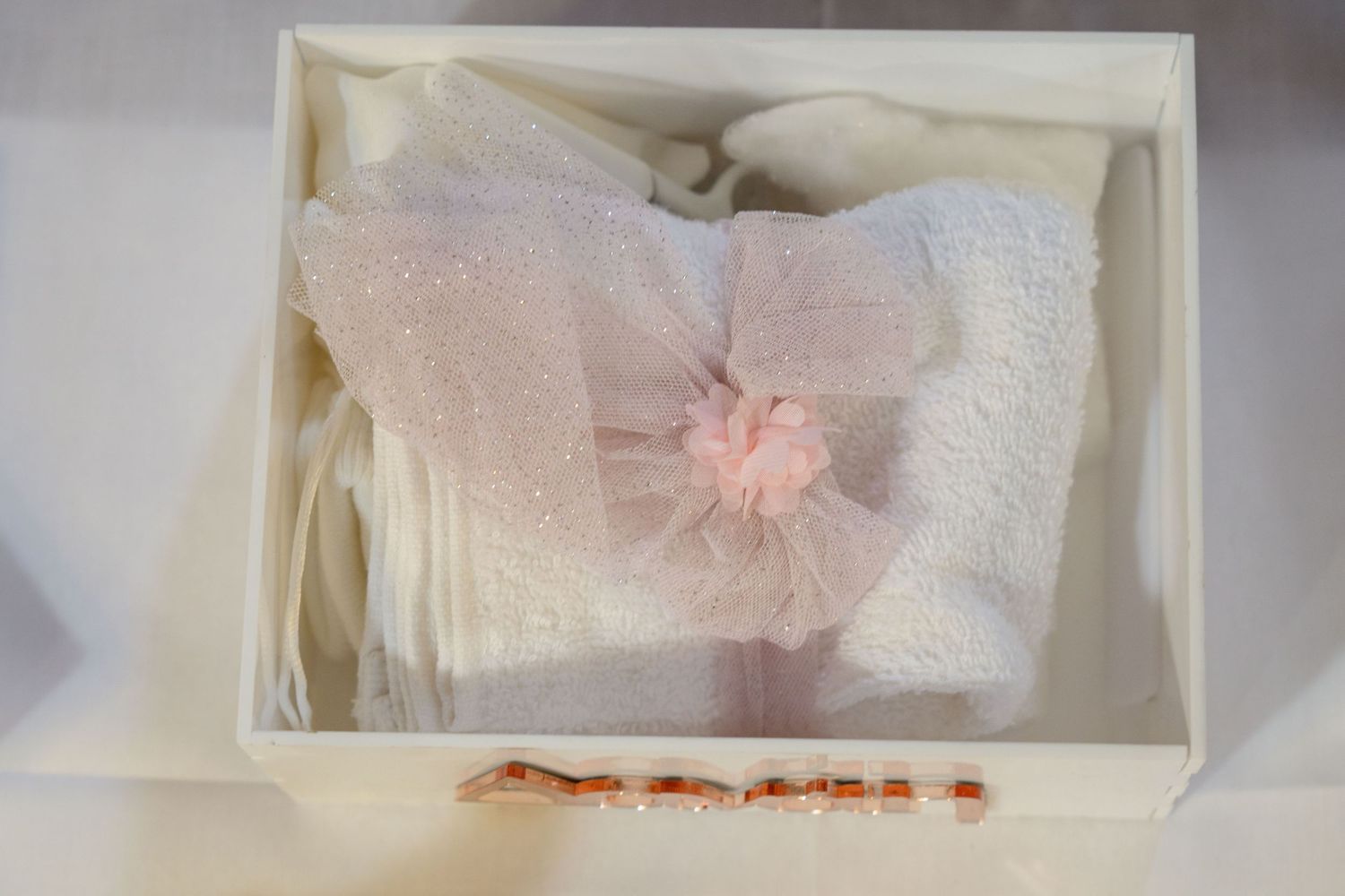 Overhead view of white storage box with pink tulle bow accent.