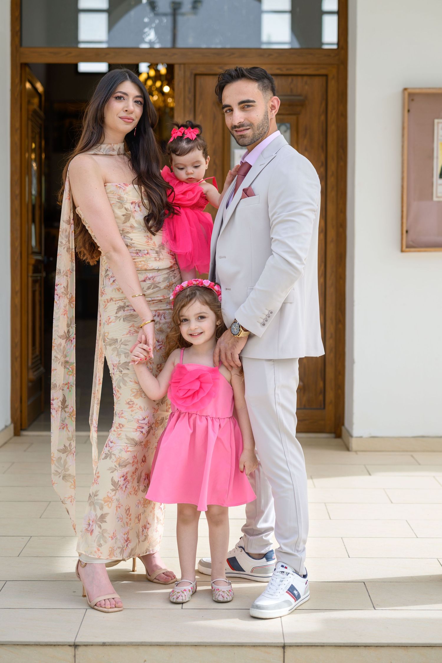 Family portrait in coordinated pink and white formal attire.