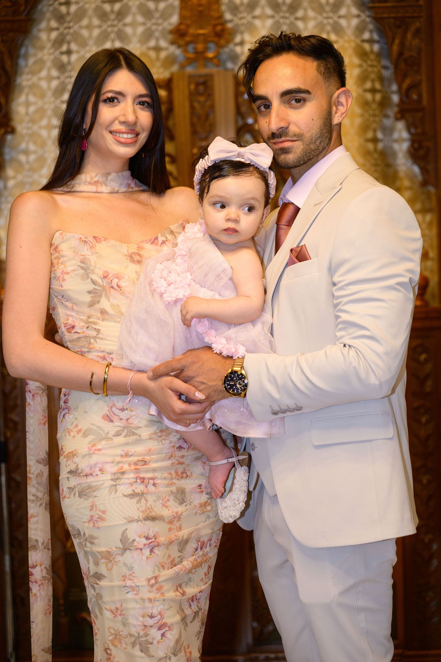 A formal family portrait in front of an ornate church backdrop during a special celebration.