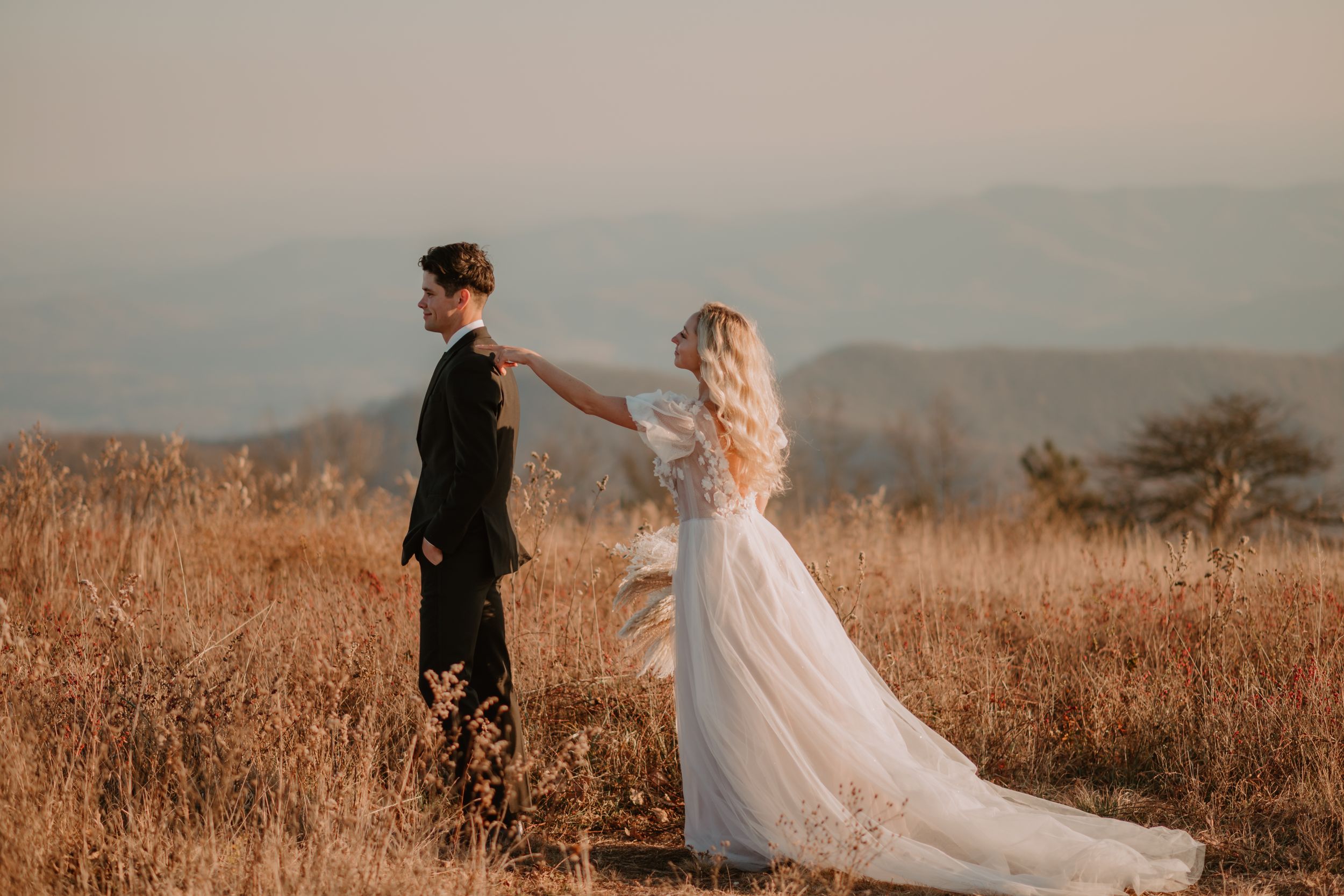 Alissa gently taps her groom, Andrew's shoulder for their first look at their mountain elopement..
