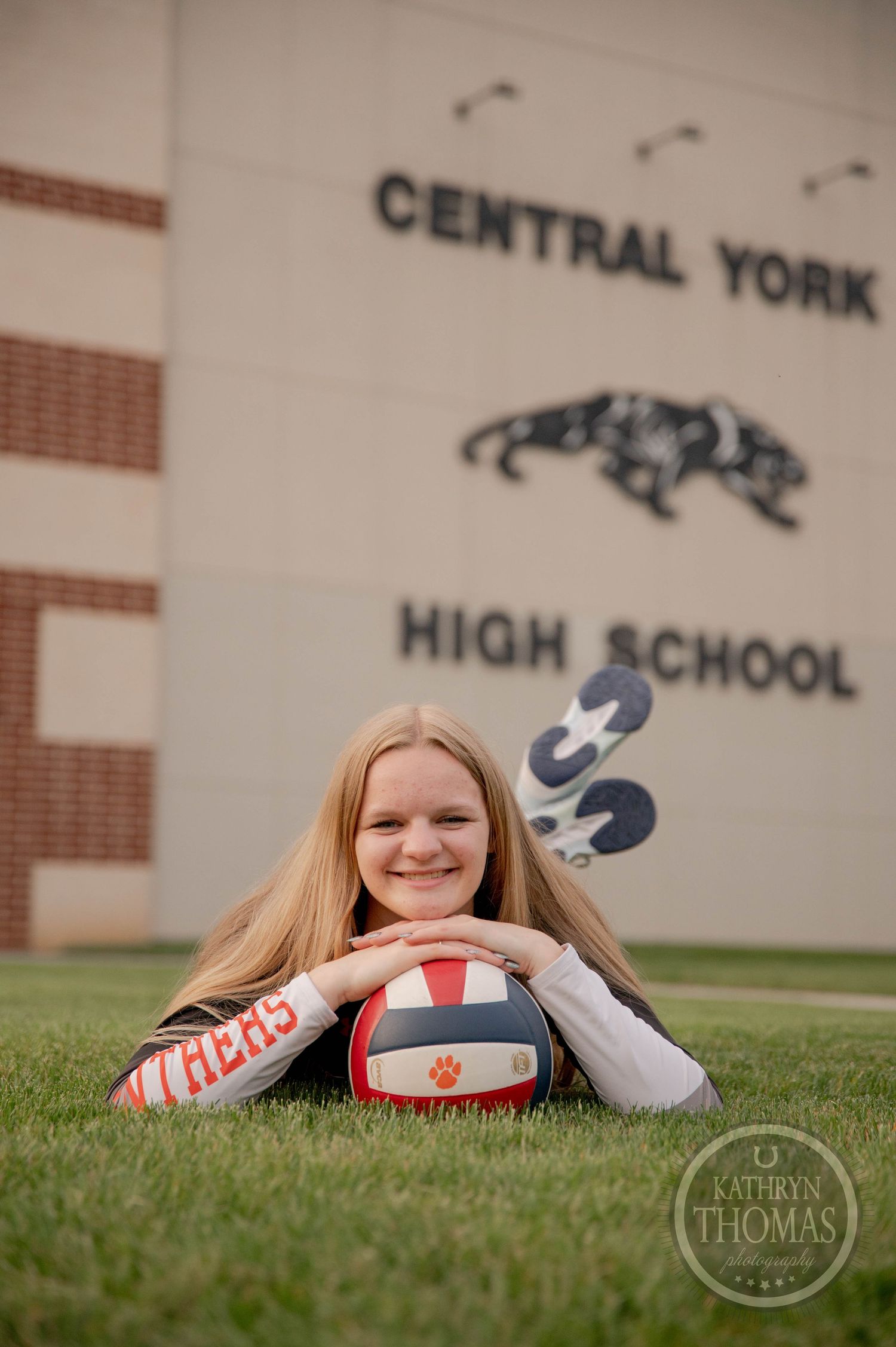 A student poses on grass near Central York High School with volleyball gear, showing school spirit.