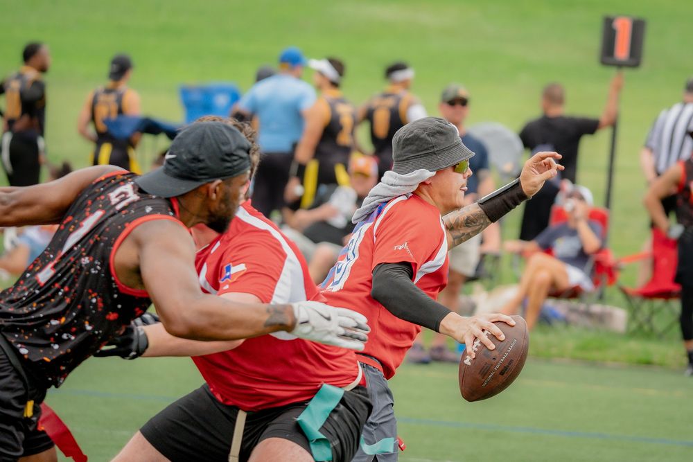 The quarterback from the Houston Hurricanes sprints forward while the rusher from Chicago Blaze persues