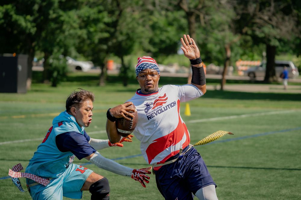 A Washington Wildcards athlete reaches for the flag of the Philadelphia Revolution quarterback at Pride Bowl
