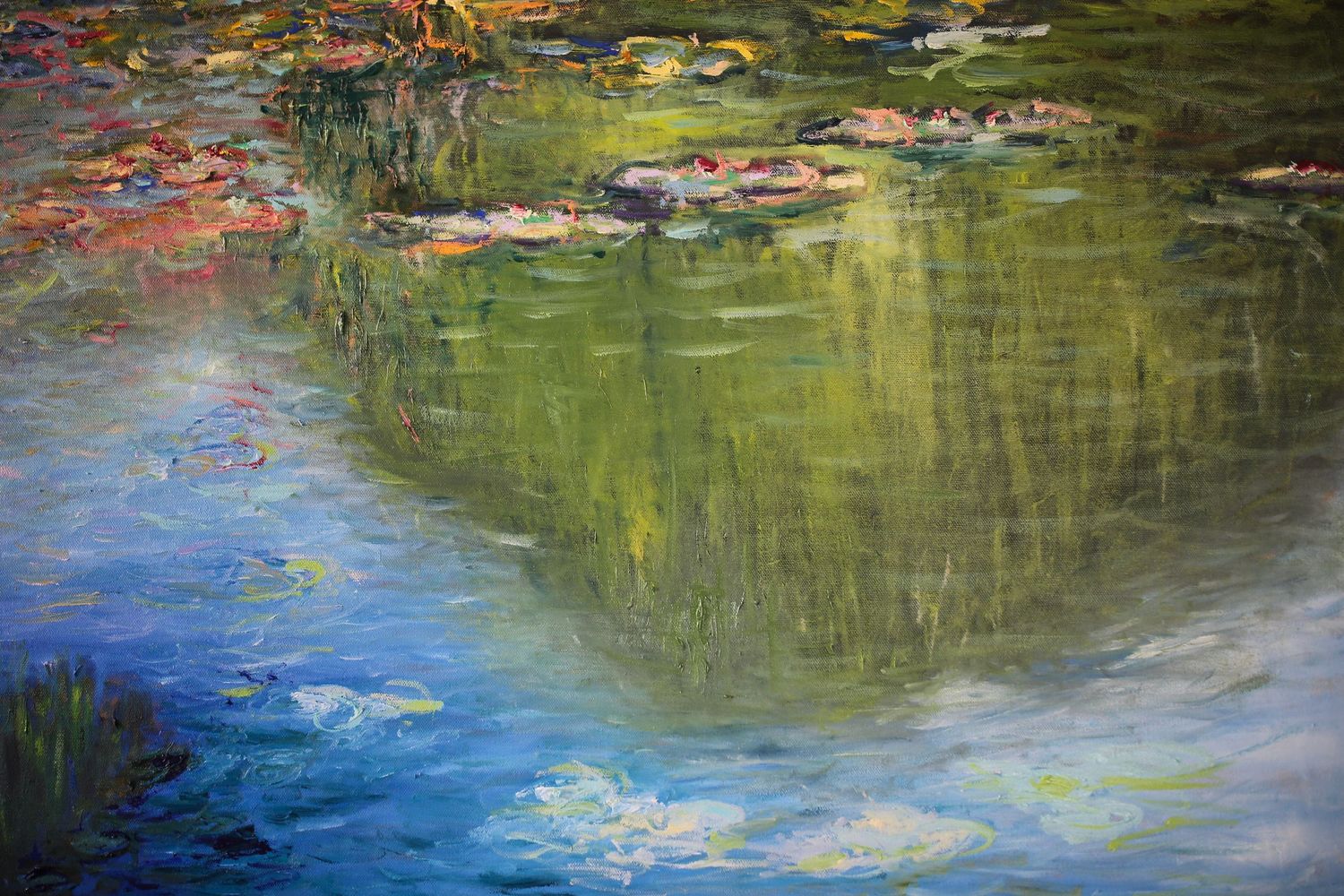 Vibrant water reflection painting creates a colorful abstract pattern with blue, green and yellow hues blending together.