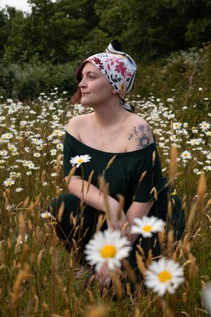 Model portrait posing in a field of daisies.