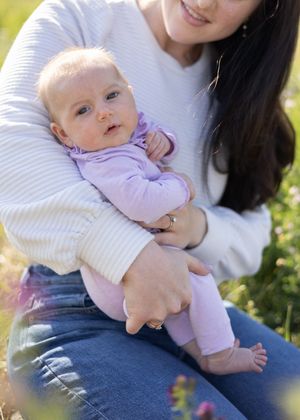 Mom and newborn baby with baby looking at camera.