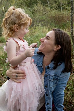 Mom and toddler daughter looking at each other and smiling.