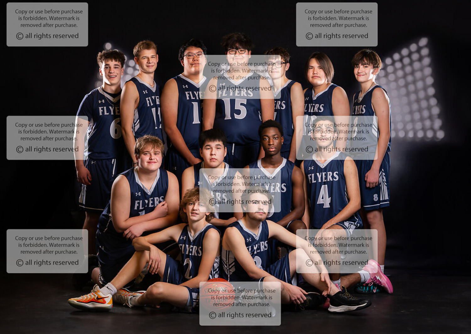 Basketball team photo featuring players in navy uniforms with stadium lighting effects in Fort Macleod Alberta