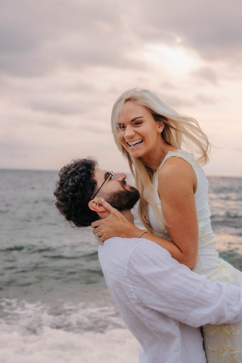 The Mediterranean sea waves crashing behind a hugging couple.
