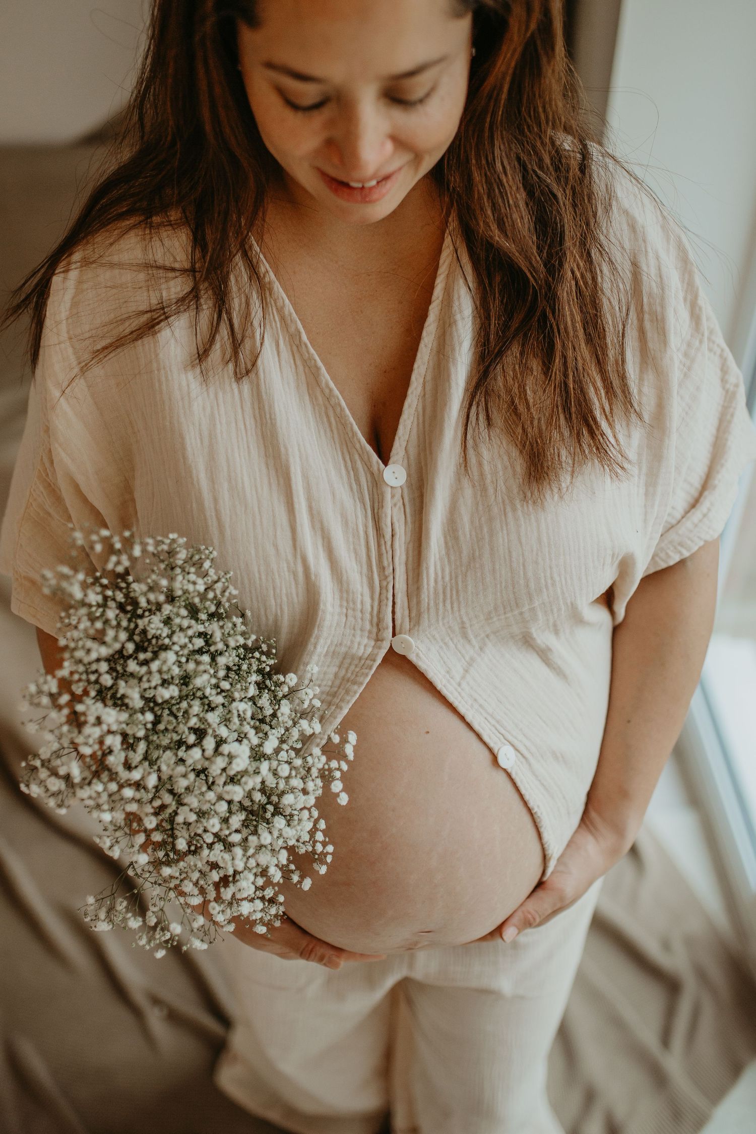 A person in a white shirt holds delicate baby's breath flowers in a series of soft, romantic lifestyle photos.