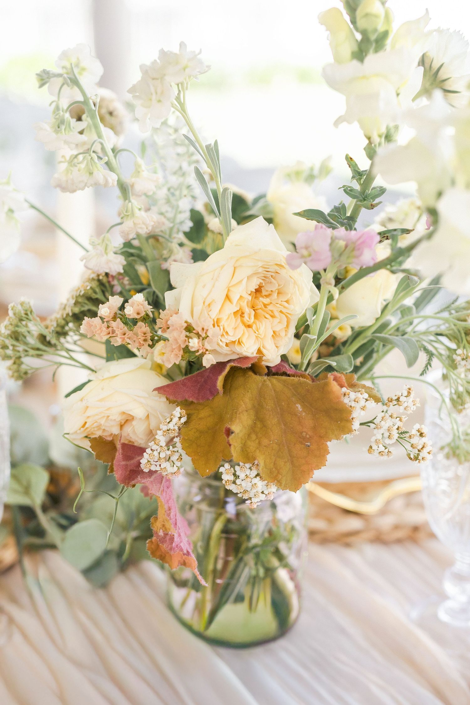 Elegant white frosted cake with delicate piped details and roses displayed on a white pedestal cake stand photographed by Chelsee Rawe Photo