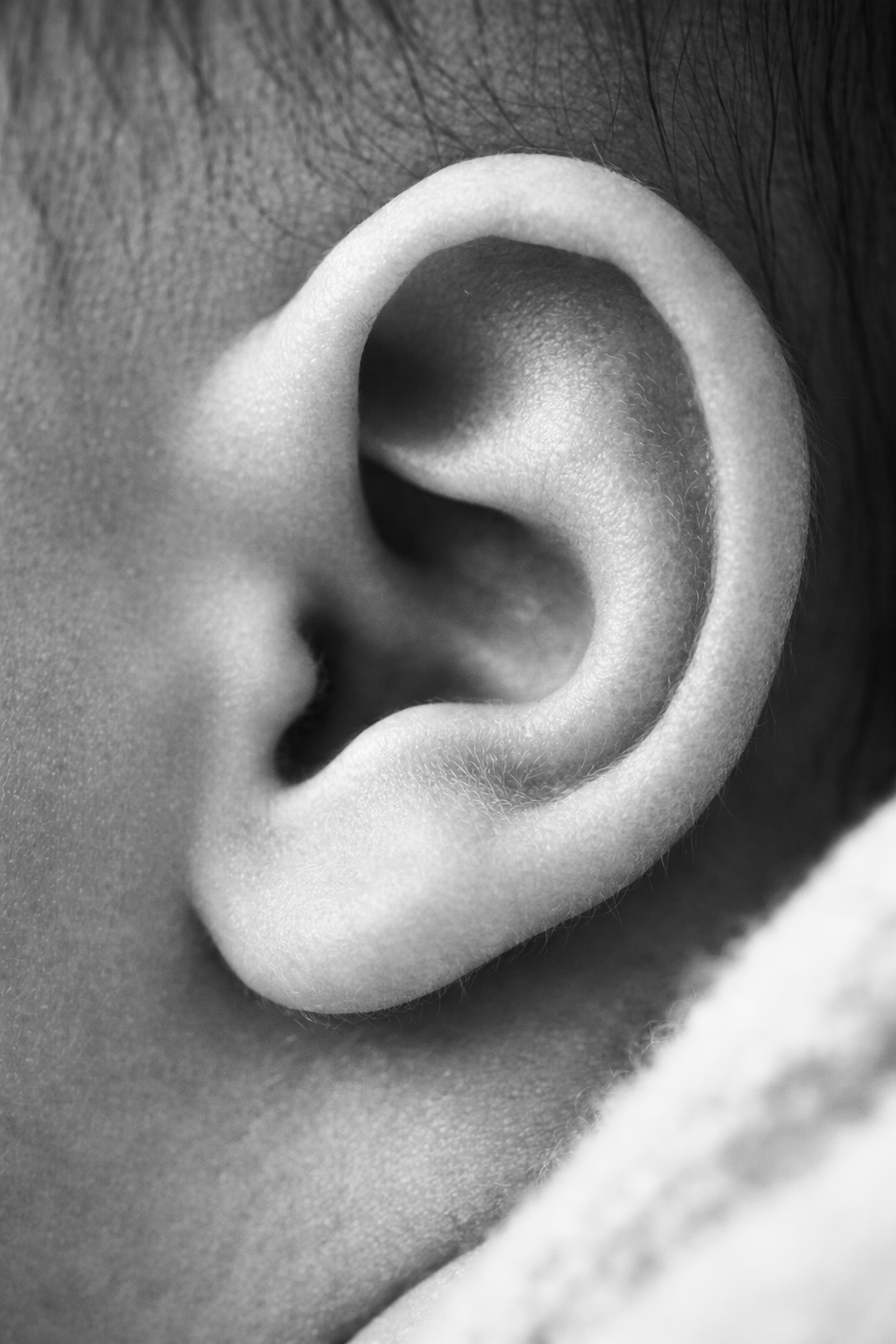 Close-up black and white sequence of a human ear showing different angles.