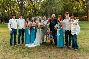 Wedding party poses outdoors in coordinated blue and white attire surrounded by autumn trees. wedding photography st louis