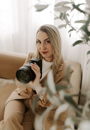 Soft natural light streams through window onto beige sofa with indoor plants creating cozy photography setting.