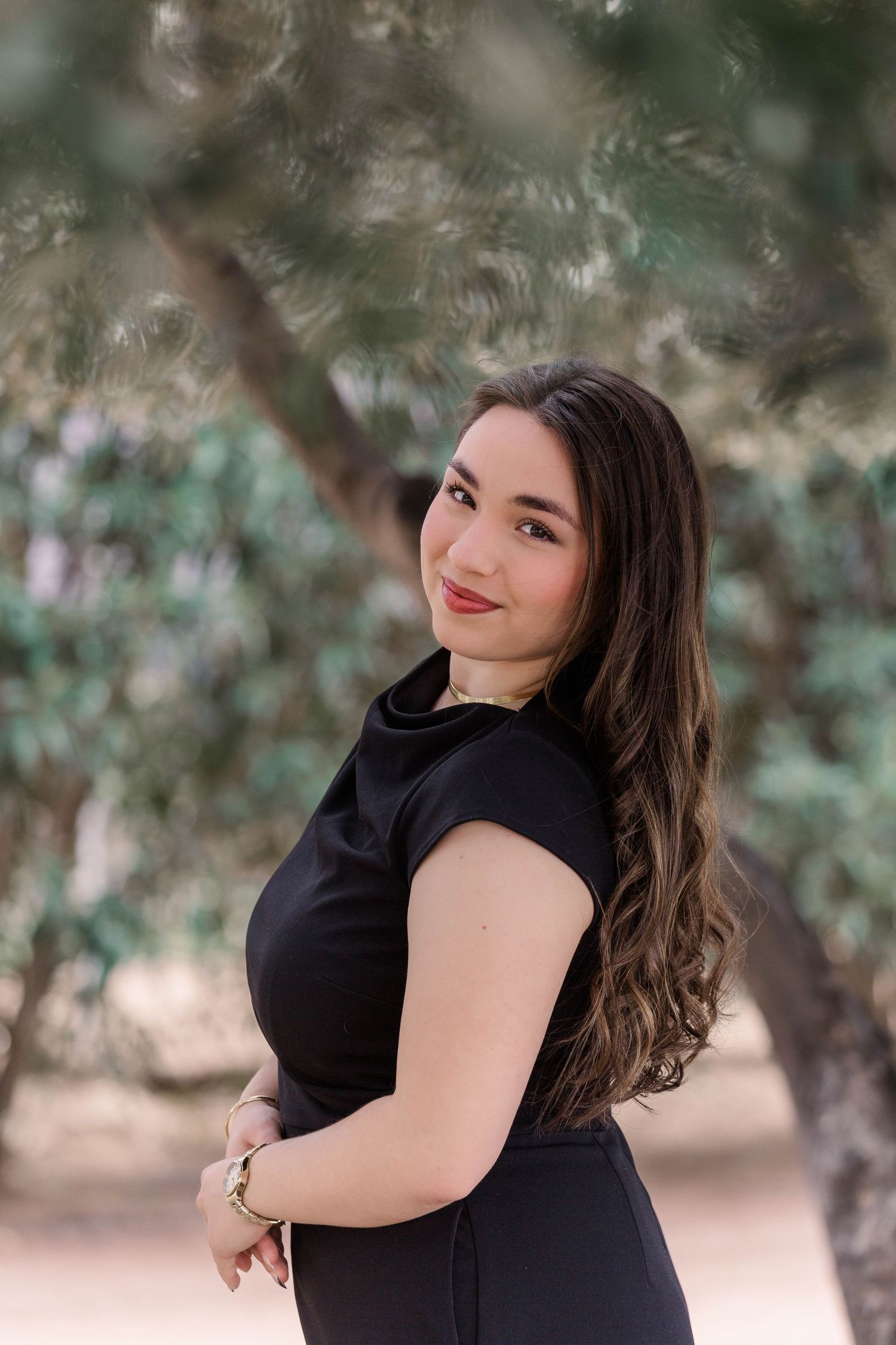 Portrait photo series in natural outdoor setting with blurred greenery background and black sleeveless outfit.
