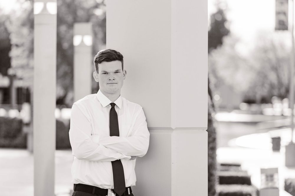 Series of black and white portraits showing formal business attire against white columns.