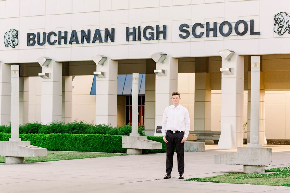 Exterior view of Buchanan High School building entrance with columns and signage mounted on the wall.